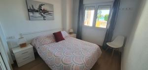 a small bedroom with a bed and a window at Primera línea playa in Roquetas de Mar +46 photos