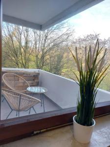 a balcony with a table and chairs and a window at Rooftop Apartments - Gemütliches Apartment 4P nahe Ratiopharm Arena in Neu Ulm