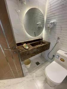 a bathroom with a toilet and a sink and a mirror at Al Somow Chalets in Dahaban +14 photos