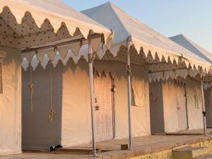 una fila di tende con le porte aperte di Janj Desert Camp Jaisalmer a Jaisalmer