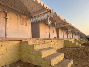 una fila di edifici con gradini anteriori di Janj Desert Camp Jaisalmer a Jaisalmer