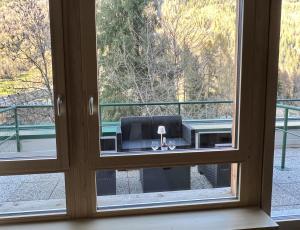 a window with a view of a table seen through it at Amba Chalet Famiglia Cima - Quadrilocale 6 posti letto in Mezzana