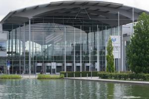 a large glass building with a pond in front of it at WEIDEN51 - Apartment für Business & Familien in Fürstenfeldbruck +34 photos