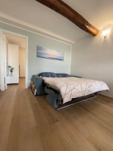 a bedroom with a bed in a room with a wooden floor at Your Sea Escape in Riva Trigoso