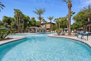 una piscina en un resort con palmeras en The Laurel Apartments in Chandler, en Chandler