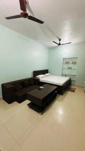 a living room with a couch and a bed at Chandrika Residency in Jhūsi +9 photos
