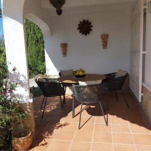a dining room with a table and chairs on a patio at Casa los Limones Torrox in Torrox