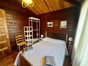 a bedroom with a bed and a wooden wall at Cabaña El Paraíso in Manzanera