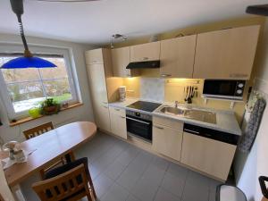 a small kitchen with a sink and a table at Ferienwohnung Schmahl in Schleiden