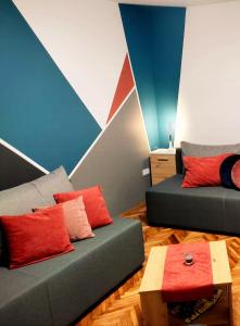 a living room with two couches and a colorful wall at Ravena in Palić