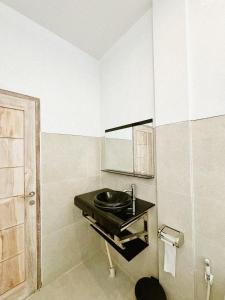 a bathroom with a black sink and a mirror at Batur Exotic Villa in Kubupenlokan +73 photos