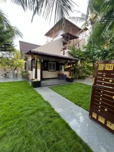 a house with a green lawn in front of it at Seaside Serenity in Mahabalipuram +19 photos