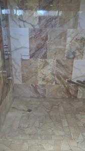 a shower with a glass door in a bathroom at Val's Waterfront Ecoluxe Cottage in Blue Hole +41 photos