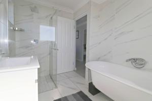 a white bathroom with a tub and a sink at NeverEndingStory in Yzerfontein +19 photos
