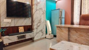sala de estar con TV y nevera en AK Royal Guest House Service Greater Noida West, en Greater Noida