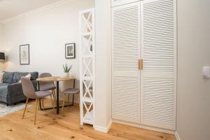 a living room with a dining room table and a sliding door at Light and bright - central stay in Pärnu
