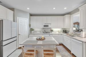 a kitchen with white cabinets and a table and chairs at Spacious Urban Uptown Retreat townhouse in Dallas