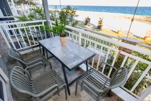 a table and chairs on a balcony with the beach at House Kohili in Nea Vrasna