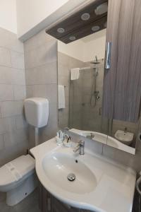 a white bathroom with a sink and a toilet at Hotel Giulietta e Romeo in Casal Palocco