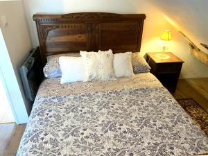 a bedroom with a large bed with a wooden headboard at Le Petit Donjon at Chateau Mareuil in Brigueuil-le-Chantre +29 photos