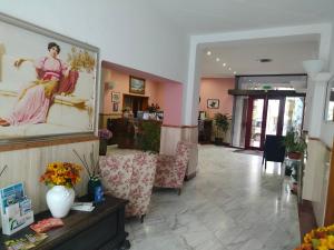 hol z krzesłami i obrazem kobiety w obiekcie Hotel Centrale w mieście Piombino