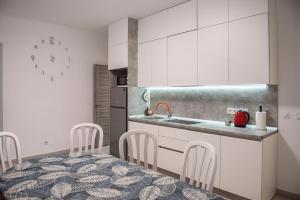 a kitchen with white cabinets and a table and chairs at Zarinok House in Skole