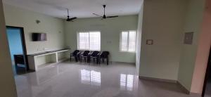 a waiting room with chairs and a counter in a building at Mani Kasthuri Illam in Tiruvannāmalai