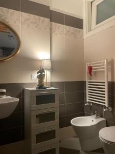 a bathroom with a sink and a toilet and a lamp at La Casa di Pino in Agerola