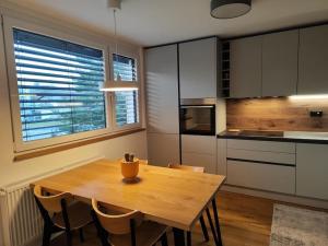 a kitchen with a wooden table and some chairs at Modern apartment Konjice in Slovenske Konjice