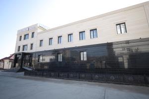 un gran edificio blanco con fachada negra en IDEAL Hotel, en Nukus