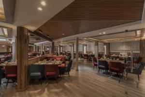 a restaurant with tables and chairs and a bar at Five Stars Nile Cruise from Luxor to Aswan 4 nights included sightseeing in Aswan