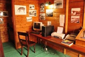 a room with a desk with a computer and a telephone at Ormiston House in Strahan