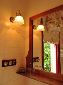 baño con espejo y lavabo con ventana en Ormiston House, en Strahan
