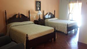 Łóżko lub łóżka w pokoju w obiekcie Hotel Acropolis Maya