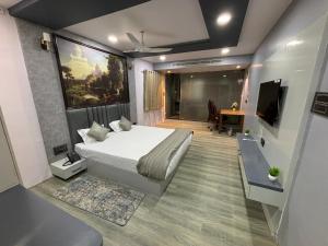 a bedroom with a bed and a desk and a television at Hotel MM Prestige in Jagdalpur