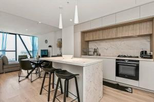 a kitchen with a counter and stools in a room at Luxury apartment in Melbourne in Melbourne