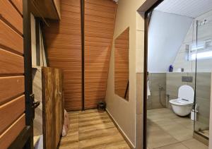 La salle de bains est pourvue de toilettes et d'une porte en verre. dans l'établissement Wild root stay- Orchid Chalet, à Vythiri 22 autres photos