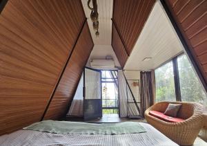 une chambre avec un lit et une grande fenêtre dans l'établissement Wild root stay- Orchid Chalet, à Vythiri