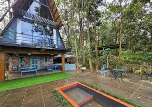 une cour arrière avec un patio et une maison dans l'établissement Wild root stay- Orchid Chalet, à Vythiri