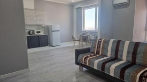un soggiorno con un divano e una cucina con un tavolo di Квартира на этаже мечты ad Aqtau Altre 4 foto