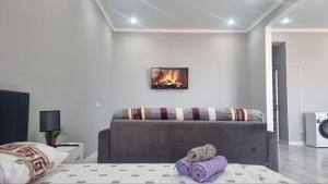 una camera da letto con un letto e un dipinto a fuoco sul muro di Квартира на этаже мечты ad Aqtau