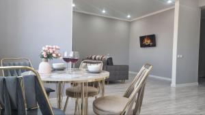 una sala da pranzo con tavolo, sedie e bicchieri da vino di Квартира на этаже мечты ad Aqtau