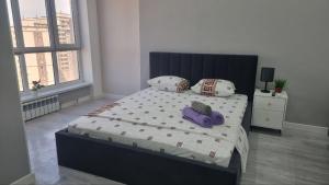 una camera con un letto con due cappelli e cuscini di Квартира на этаже мечты ad Aqtau