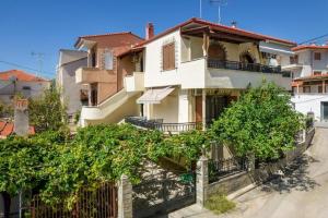 a white house with trees in front of it at Studios Anagnostou in Skala Marion