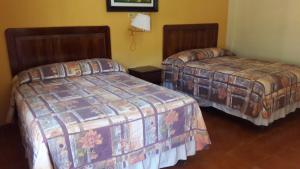 a hotel room with two beds in a room at Hotel Brisas de Copan in Copan Ruinas