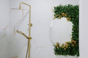 a mirror and a wreath on a wall at Gold Luxury Apartment in Bosanska Gradiška
