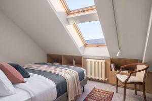 una camera mansardata con letto e sedia di Apart-In Georgia a Tbilisi City