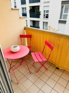 two chairs and a pink table on a balcony at Chambre spacieuse in Montmagny