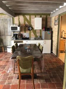 a kitchen with a table and chairs and a refrigerator at Petite maison paisible in Brillecourt +9 photos