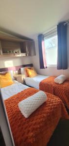 a hotel room with two beds and a window at Holiday Home at Combe Haven, St Leonards, Hastings in St. Leonards